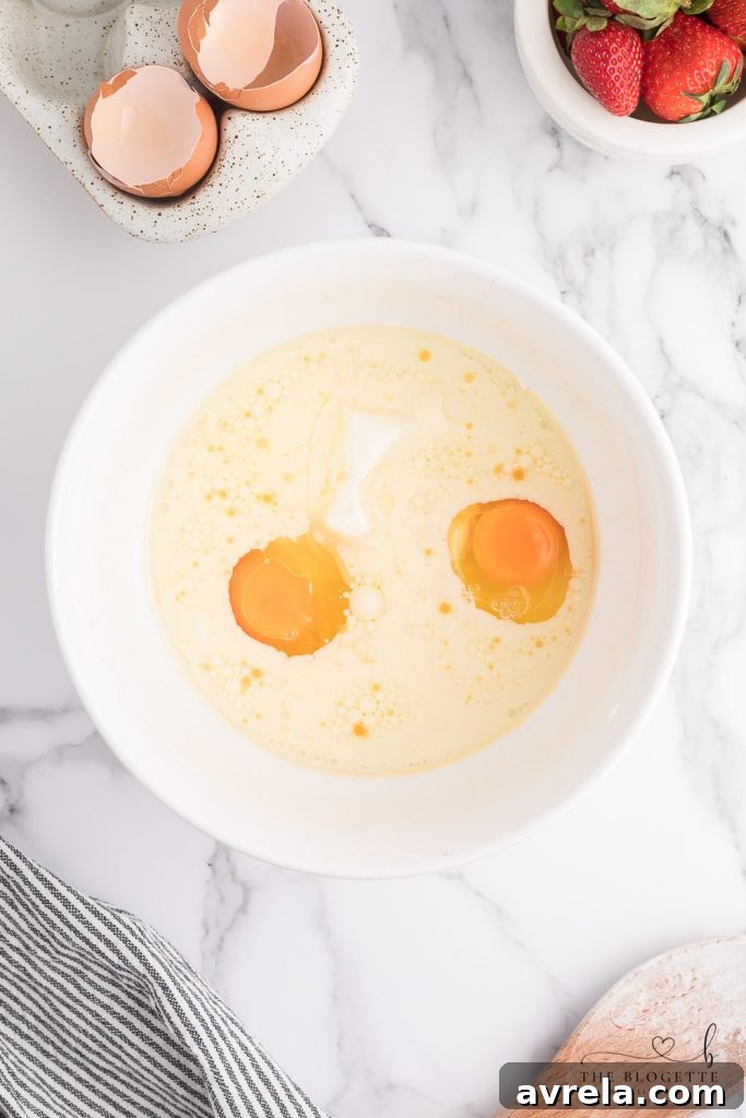 Eggs being whisked into bread batter, a key step for Strawberry Bread.