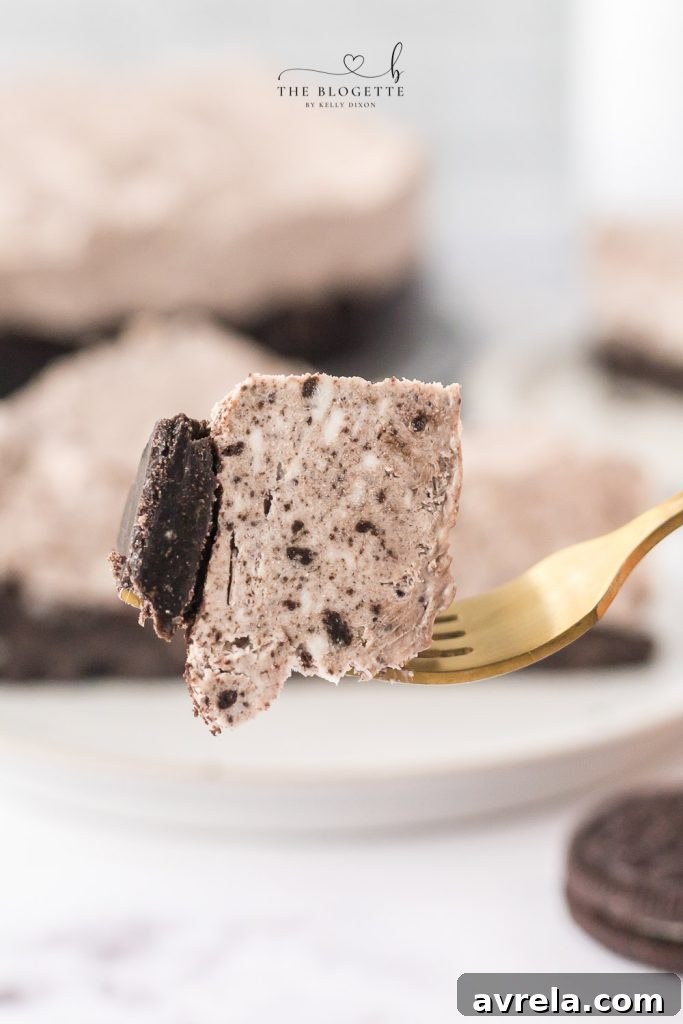 Oreo Dream Cheesecake 11 A close-up of a No Bake Oreo Cheesecake slice, showing the generous layers and crumb topping, ready to be enjoyed.