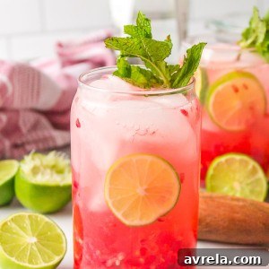 A vibrant Raspberry Mojito, garnished with fresh raspberries, lime, and mint, showcasing its inviting appearance.