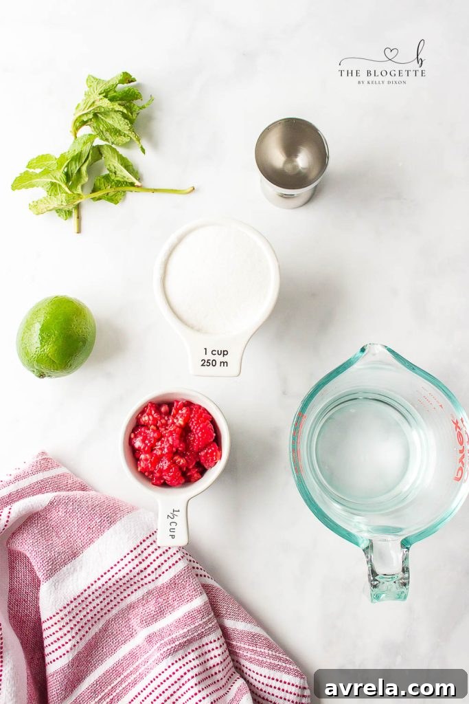 A flat lay image showing fresh raspberries, vibrant mint leaves, whole limes, and a bottle of white rum, laid out as ingredients for a mojito.