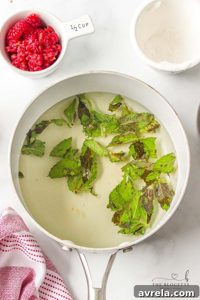 Fresh mint leaves being added to a saucepan with sugar and water, indicating the start of simple syrup preparation.