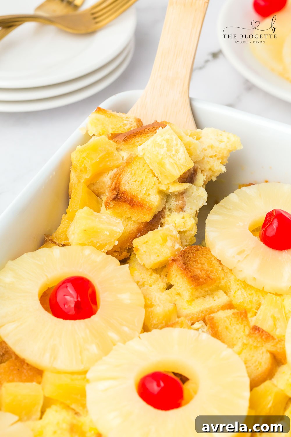 A slice of pineapple casserole with bread and pineapple chunks, garnished.