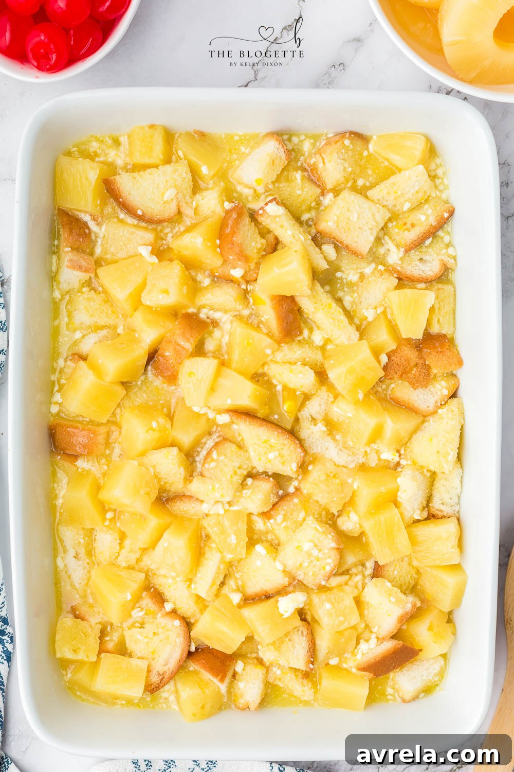 The pineapple mixture layered over bread in a baking dish, ready for the oven.