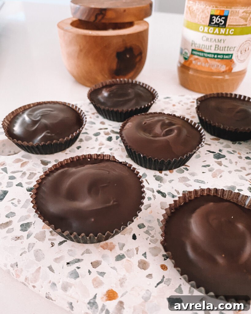 Homemade Reese's Peanut Butter Cups nestled in their classic fluted paper liners, showcasing the golden peanut butter filling within a dark chocolate shell.