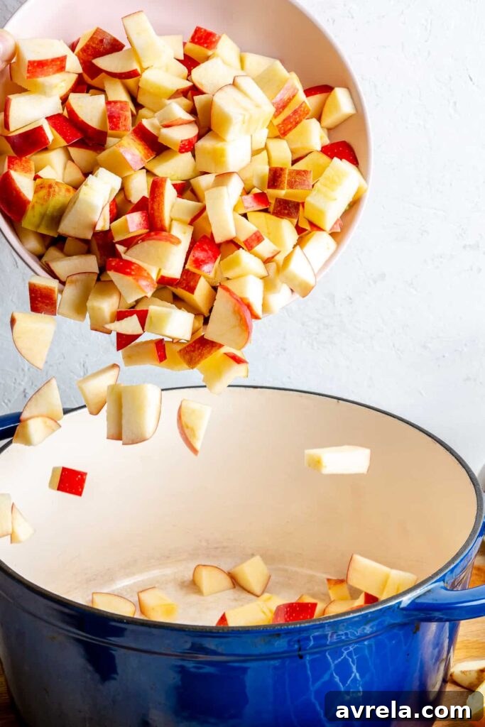 Close-up of freshly diced apples, ready for cooking, in a bowl on a rustic wooden surface.
