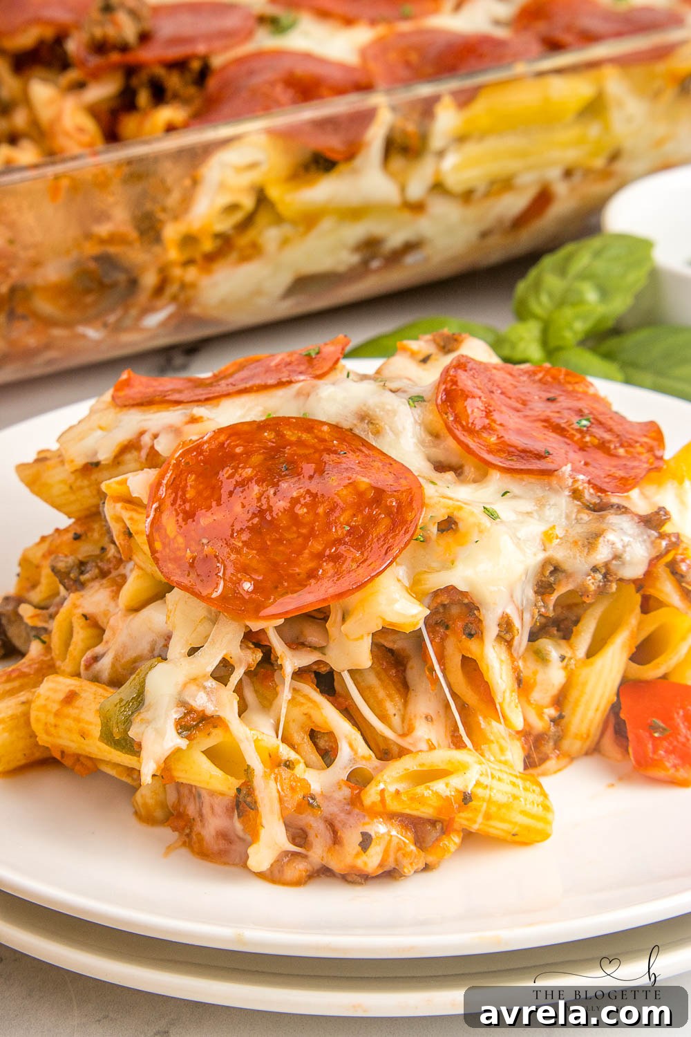 Individual serving of pizza casserole on a plate with fresh parsley garnish.
