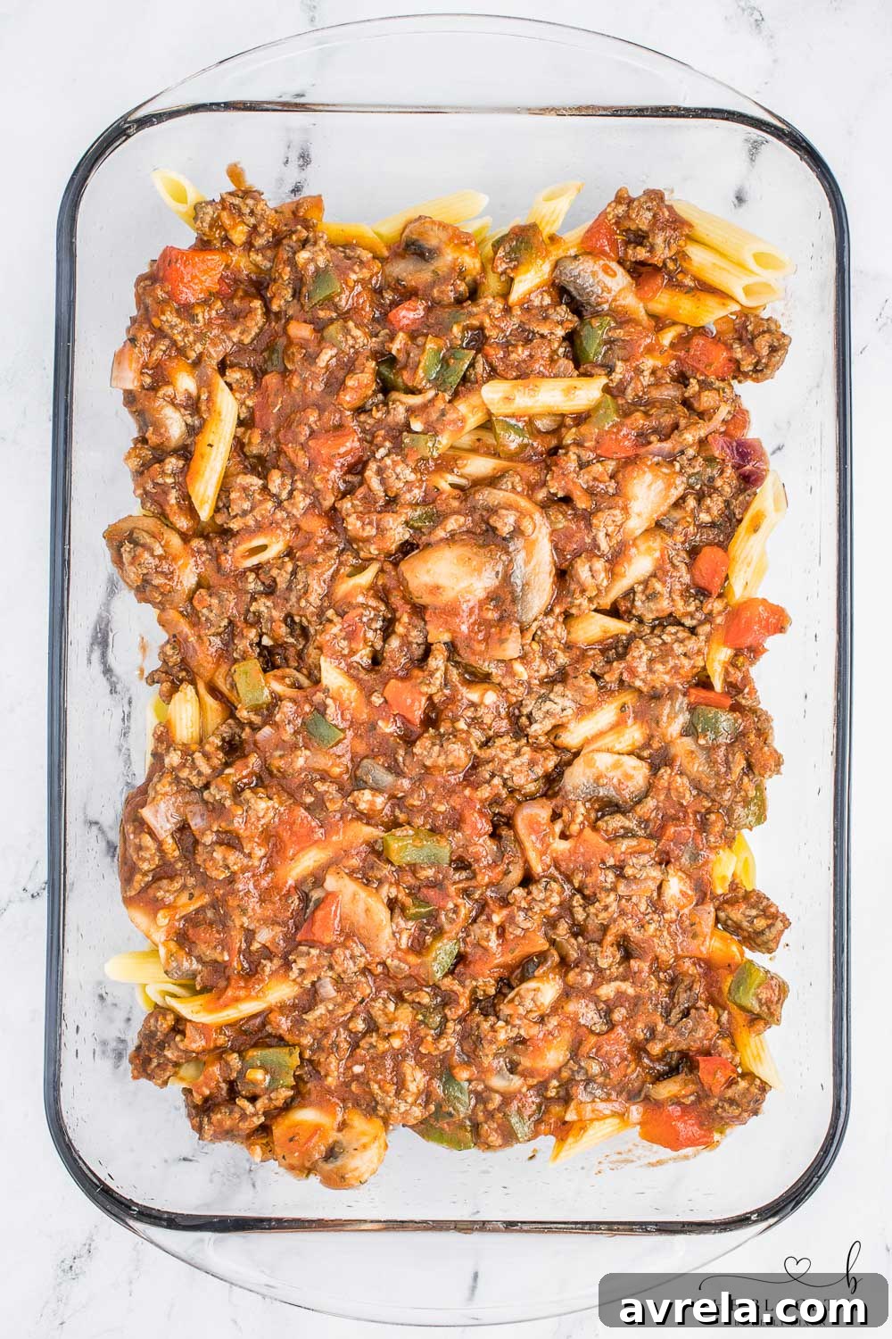 A layer of rich meat mixture spread over pasta in a casserole dish.