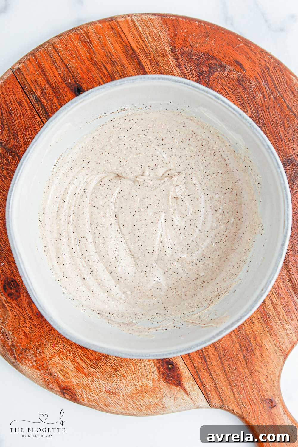 Melted white chocolate infused with apple pie spice, ready for dipping. It has a smooth, glossy texture.