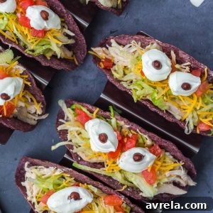 Monster Tacos for Halloween! These crock pot ranch chicken tacos feature blue corn taco shells and spooky sour cream eyes!