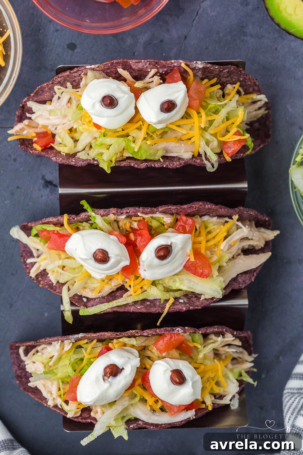 Monster Tacos for Halloween! These crock pot ranch chicken tacos feature blue corn taco shells and spooky sour cream eyes!
