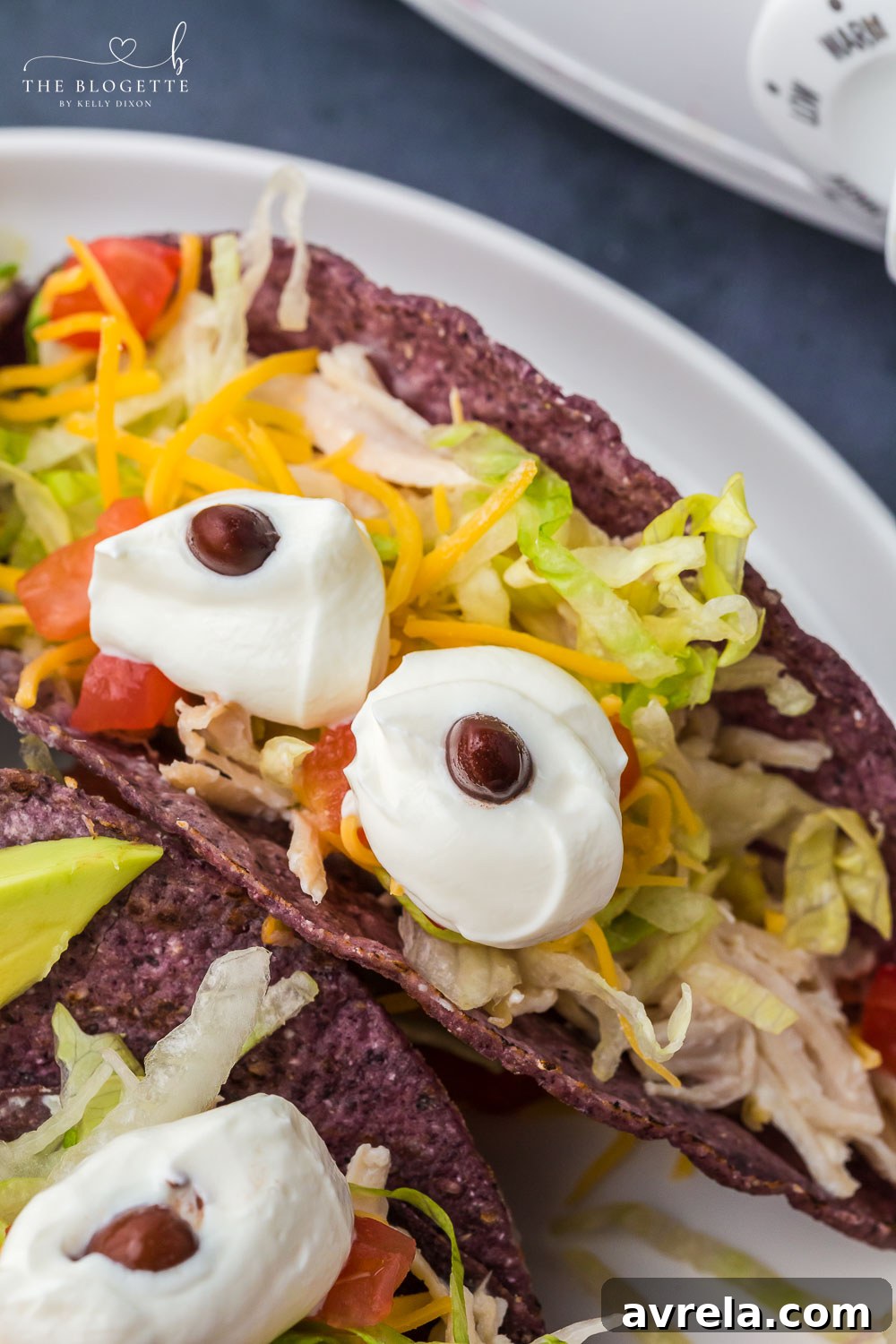 Monster Tacos for Halloween! These crock pot ranch chicken tacos feature blue corn taco shells and spooky sour cream eyes!