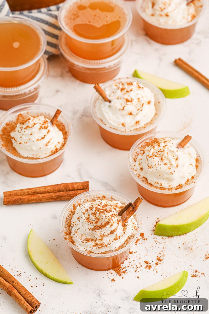 Fully prepared Apple Pie Jello Shots with Fireball, topped with whipped cream and cinnamon, ready to serve.