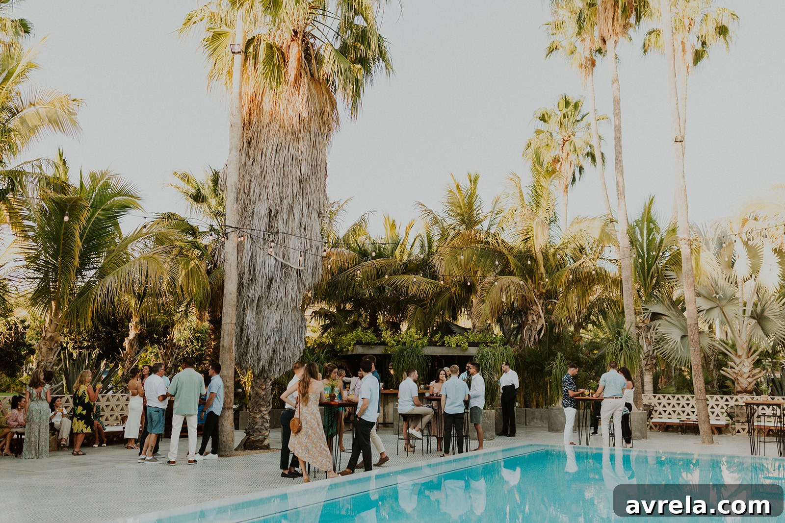 A couple holding hands and smiling as they walk through the enchanting grounds of Acre Baja