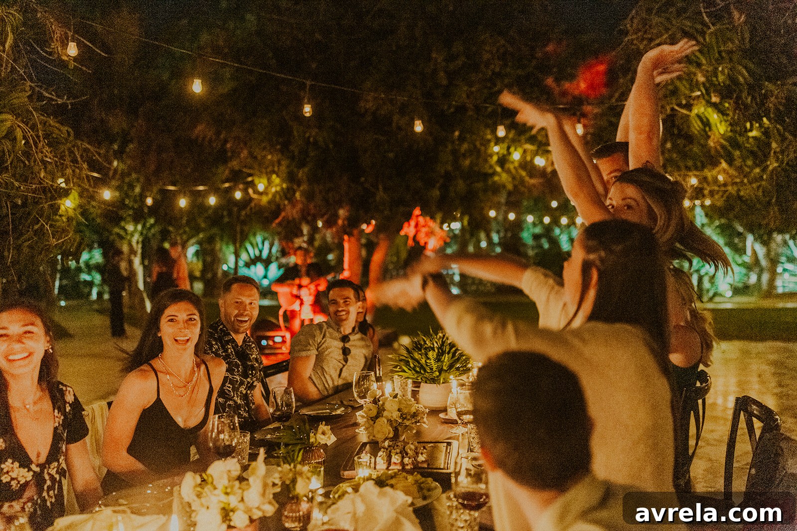The bride and groom sharing a tender dance or playful moment under the magical string lights