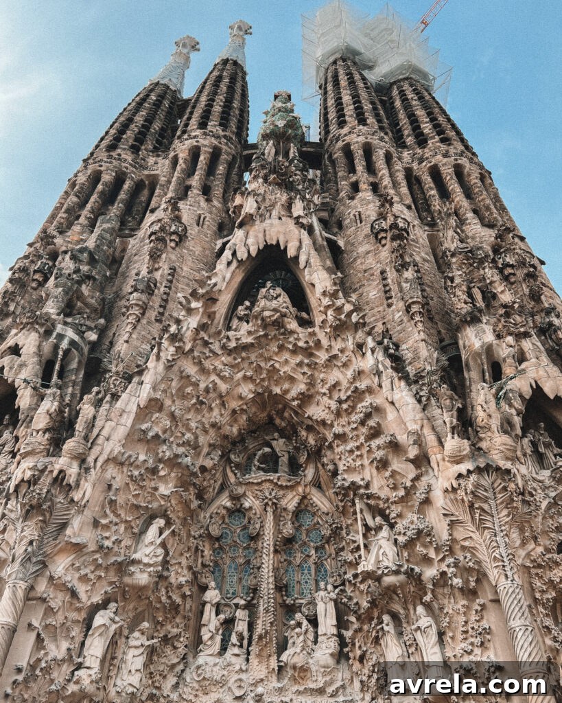 The grand interior of La Sagrada Familia, with soaring columns resembling trees and stained glass casting colorful light.