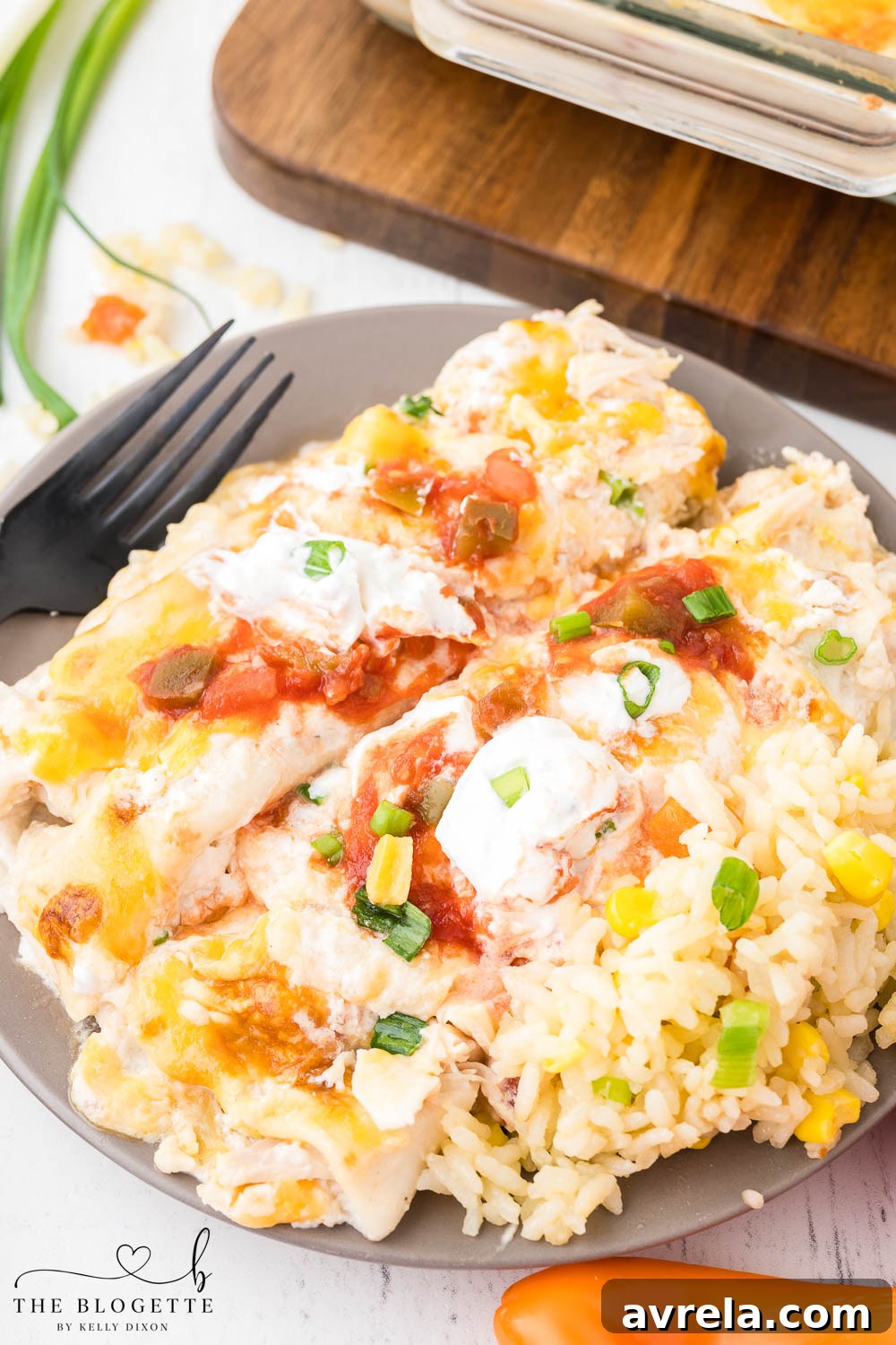 A generous serving of creamy enchiladas alongside a bed of rice, garnished with fresh herbs.