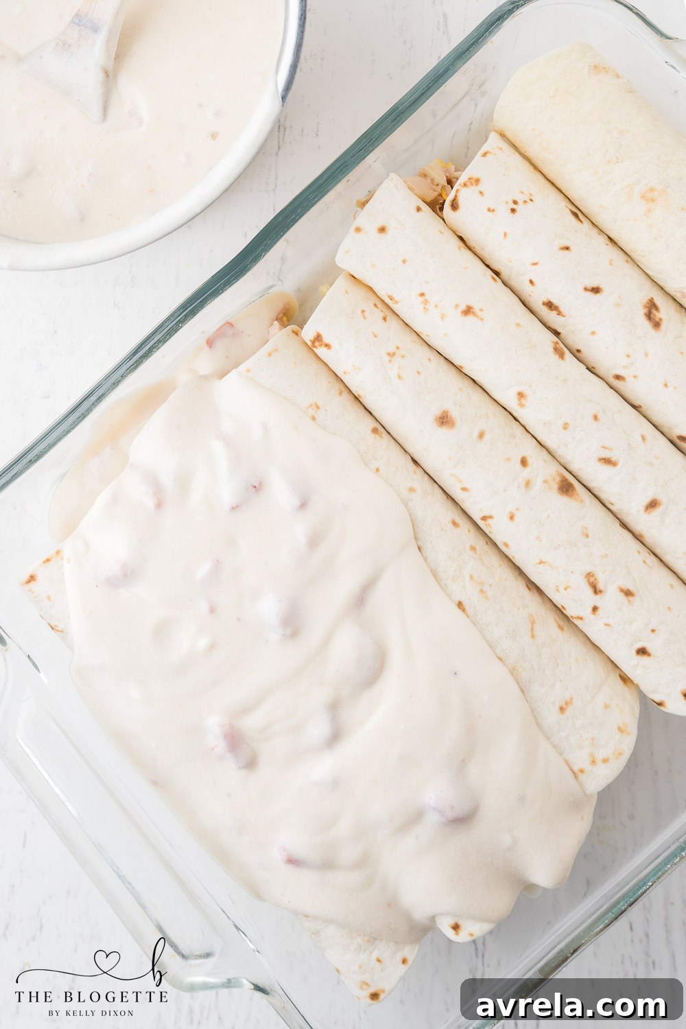 A bowl of creamy white enchilada sauce, ready to be poured over enchiladas.
