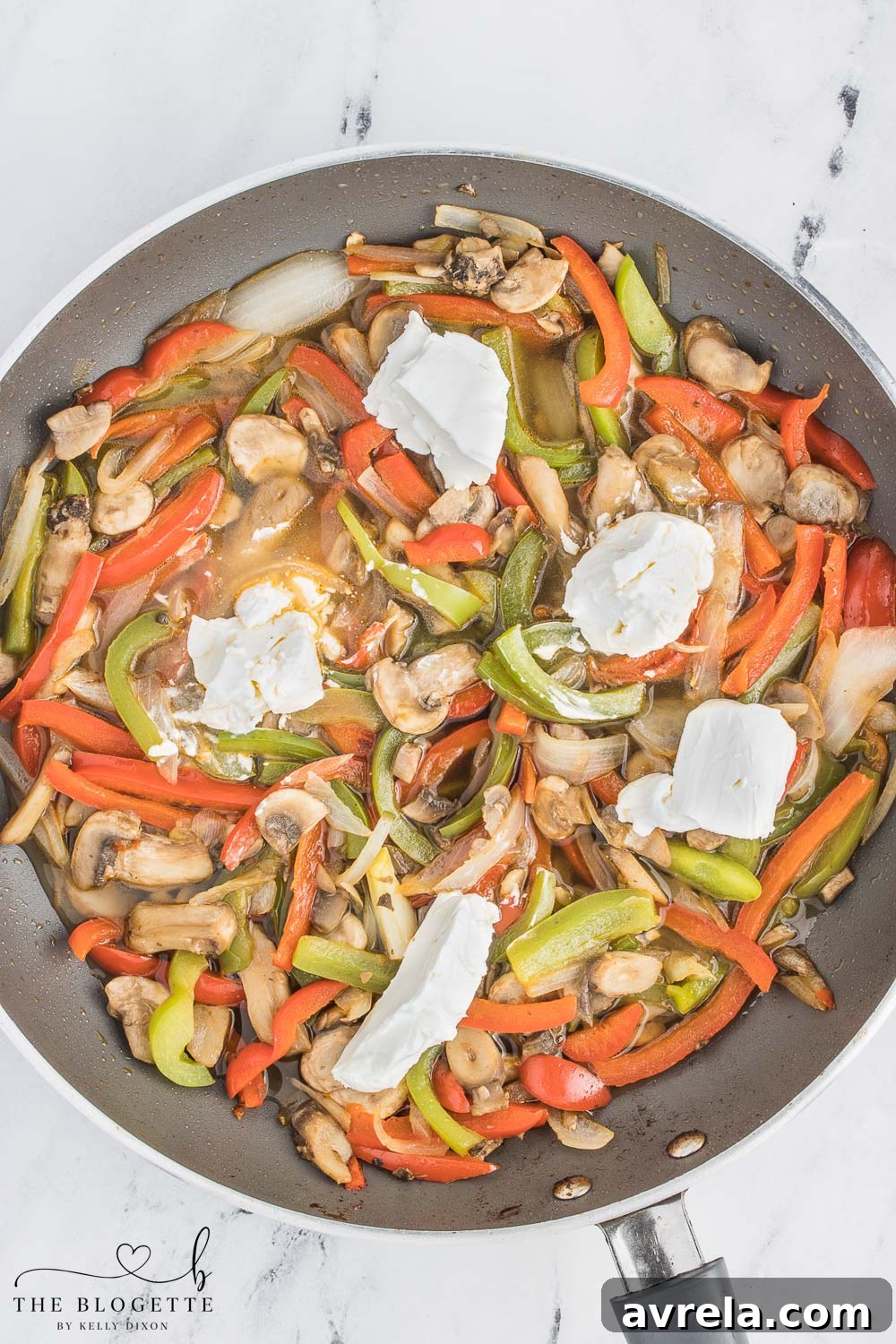 Philly Cheesesteak Comfort Bake 7 The cheesesteak mixture simmering in the skillet, with cream cheese melting into a rich, creamy sauce that coats the vegetables.