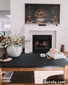 Wide view of the family room, highlighting the fireplace, paneling, and the Sixpenny sectional