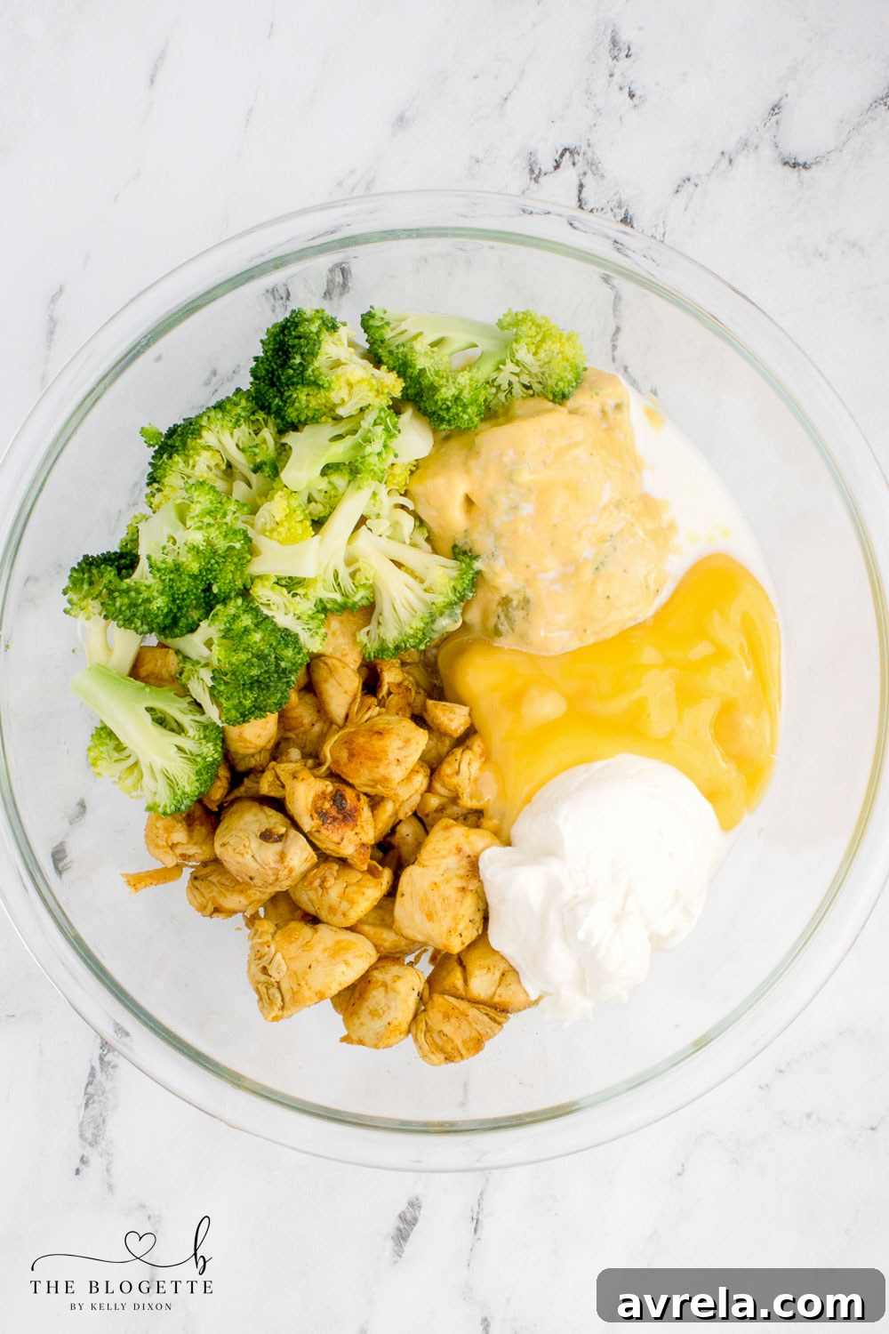 The creamy chicken mixture in a bowl, before the addition of cheese and crackers, showcasing the combined soups, sour cream, milk, and lemon juice.
