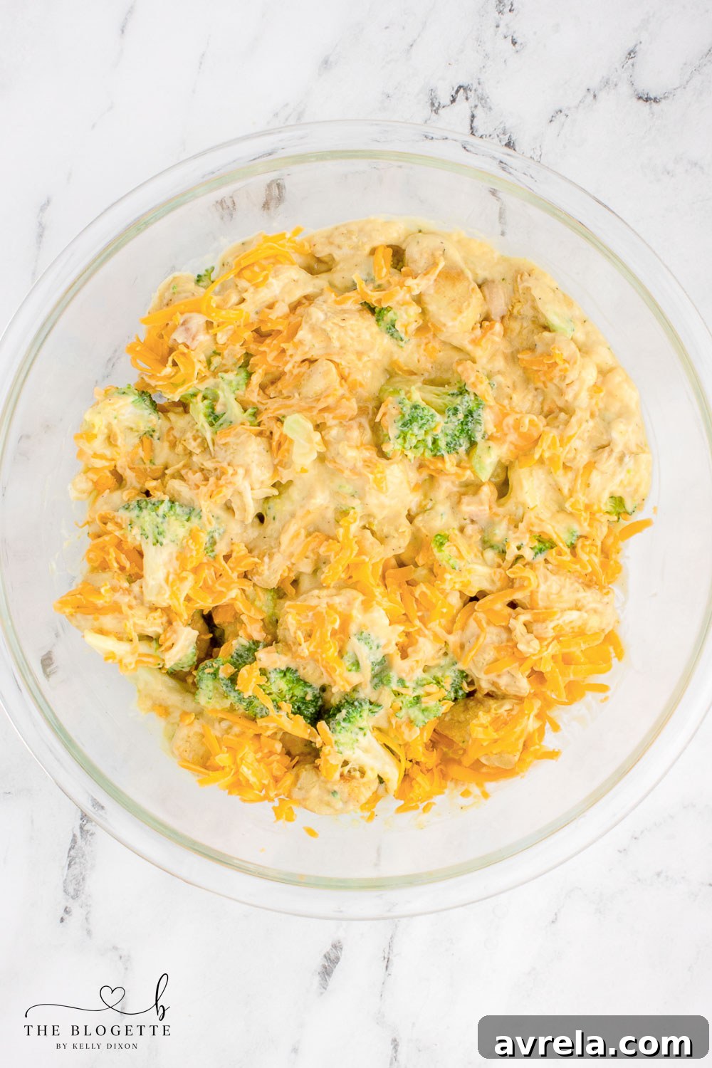 The creamy chicken and broccoli mixture with shredded cheddar cheese stirred in, ready to be transferred to the baking dish.