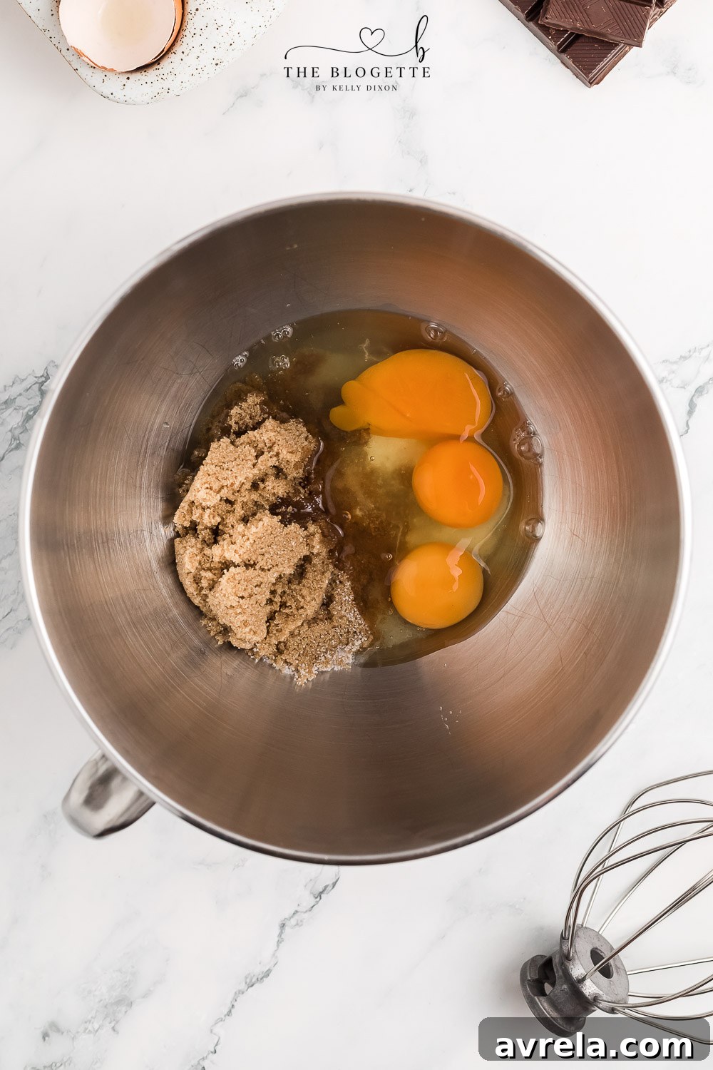 Eggs and brown sugar being beaten until light and glossy.