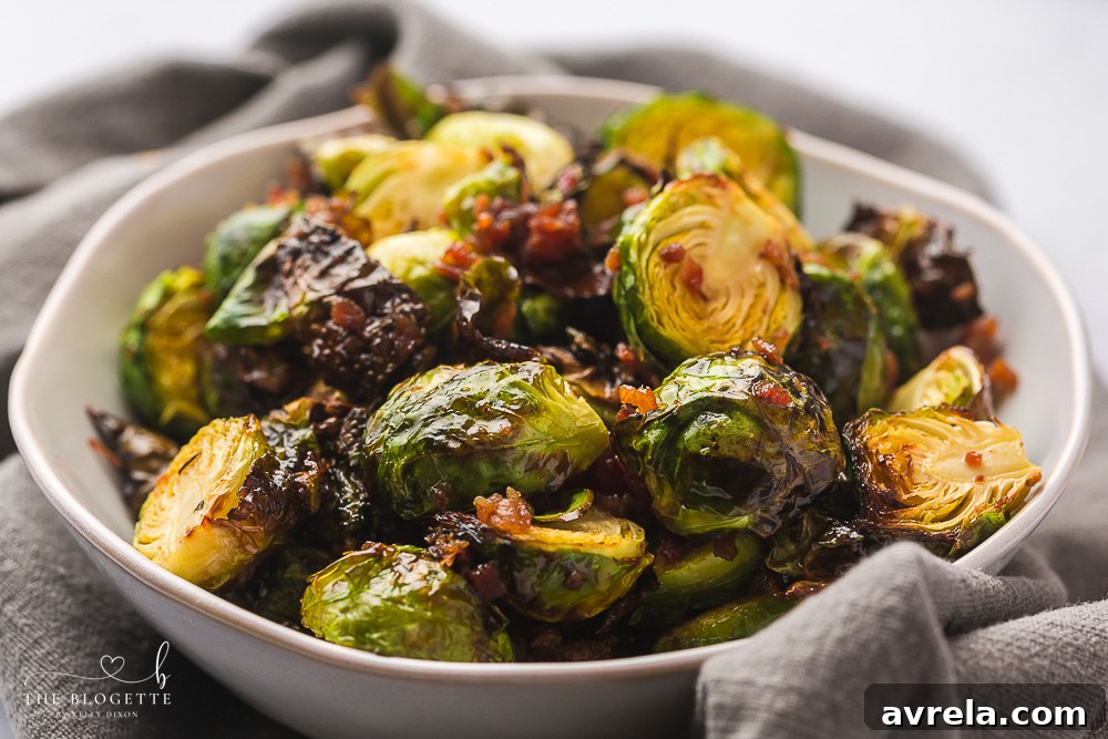Close-up of a bowl of freshly cooked Honey Bacon Brussels Sprouts, showcasing crispy bacon bits.
