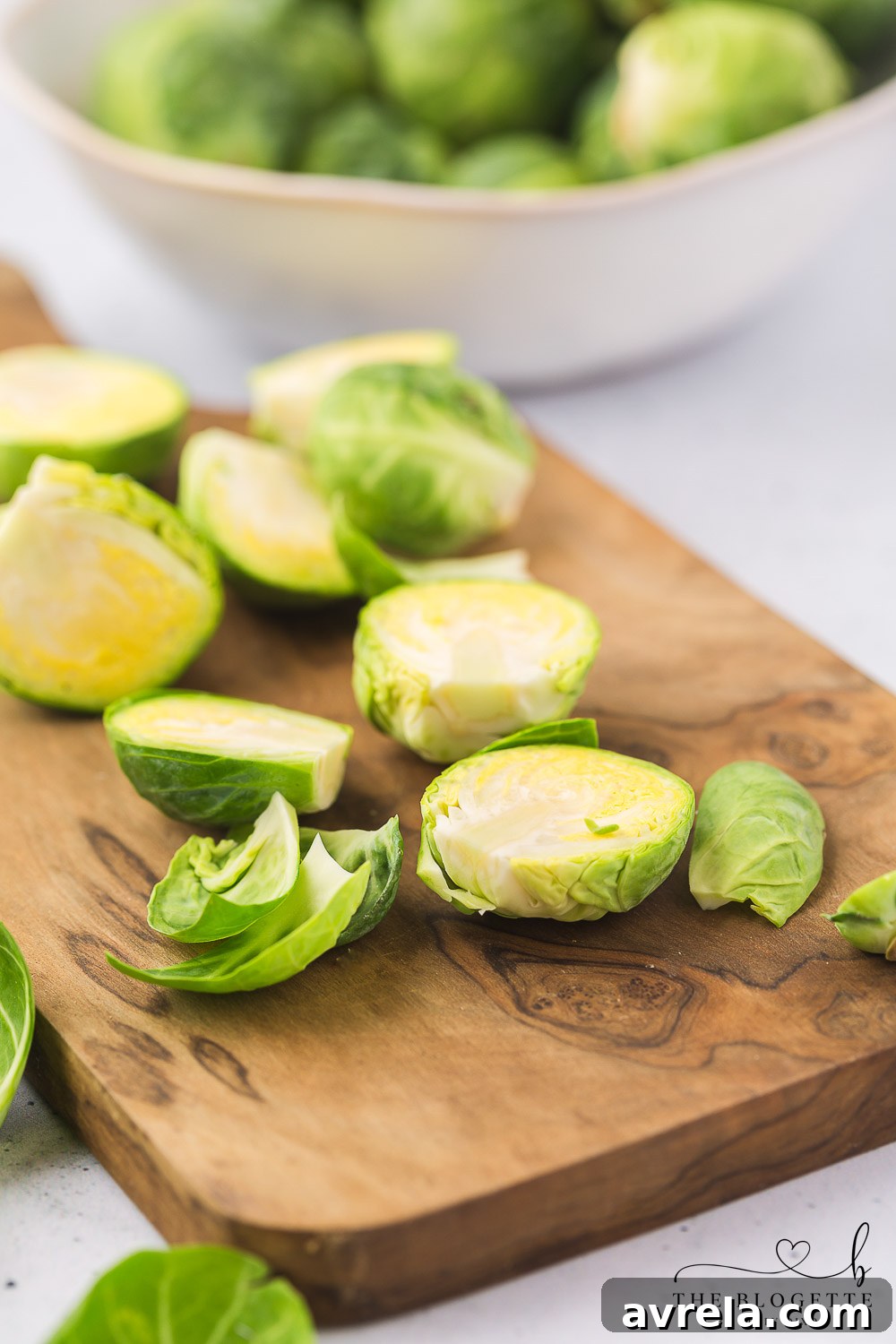Demonstration of how to trim and halve Brussels sprouts for cooking.