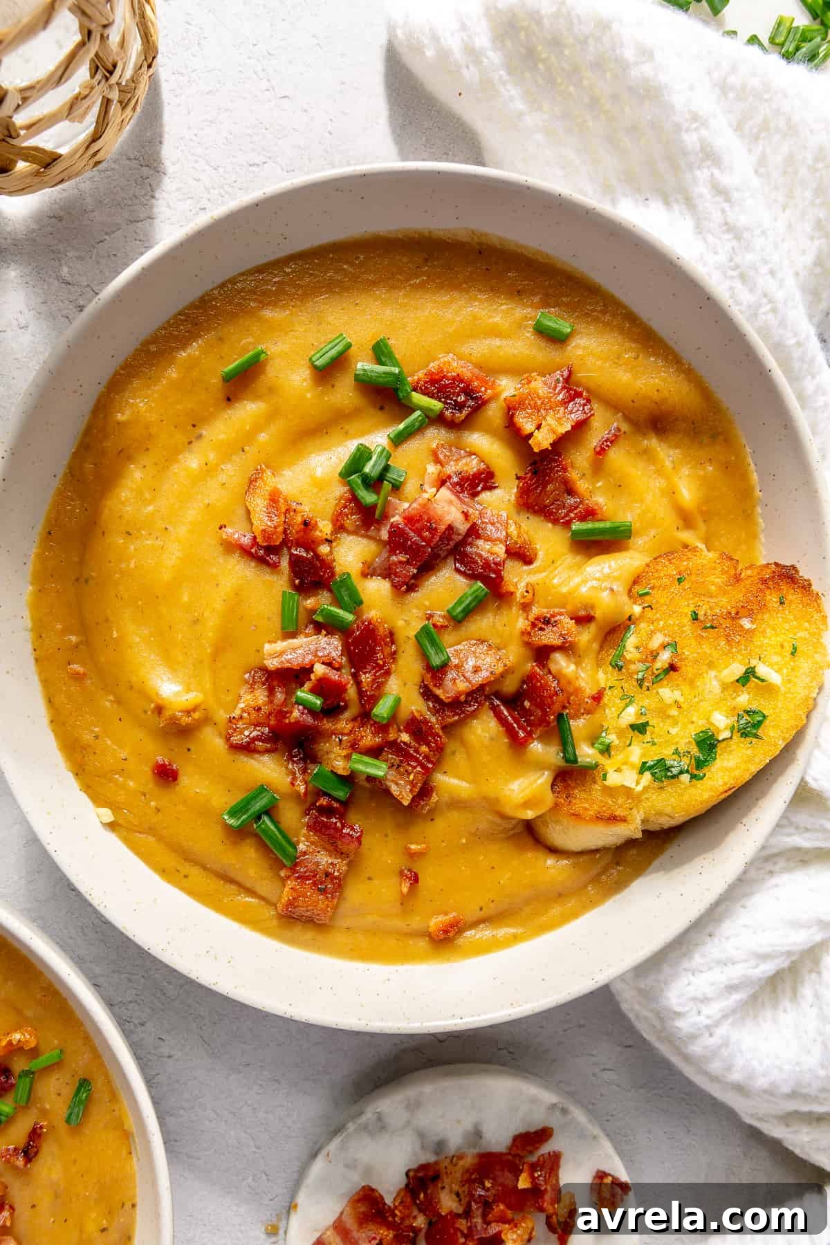 Rich and creamy potato and leek soup, garnished with bacon and chives.