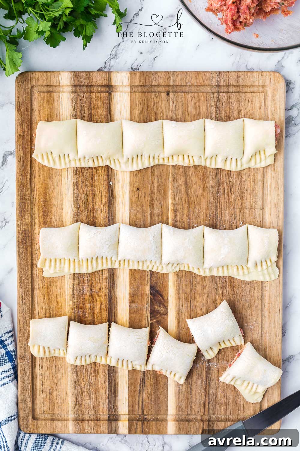 Close-up of raw sausage rolls, neatly sliced into bite-sized pieces and arranged on parchment paper.