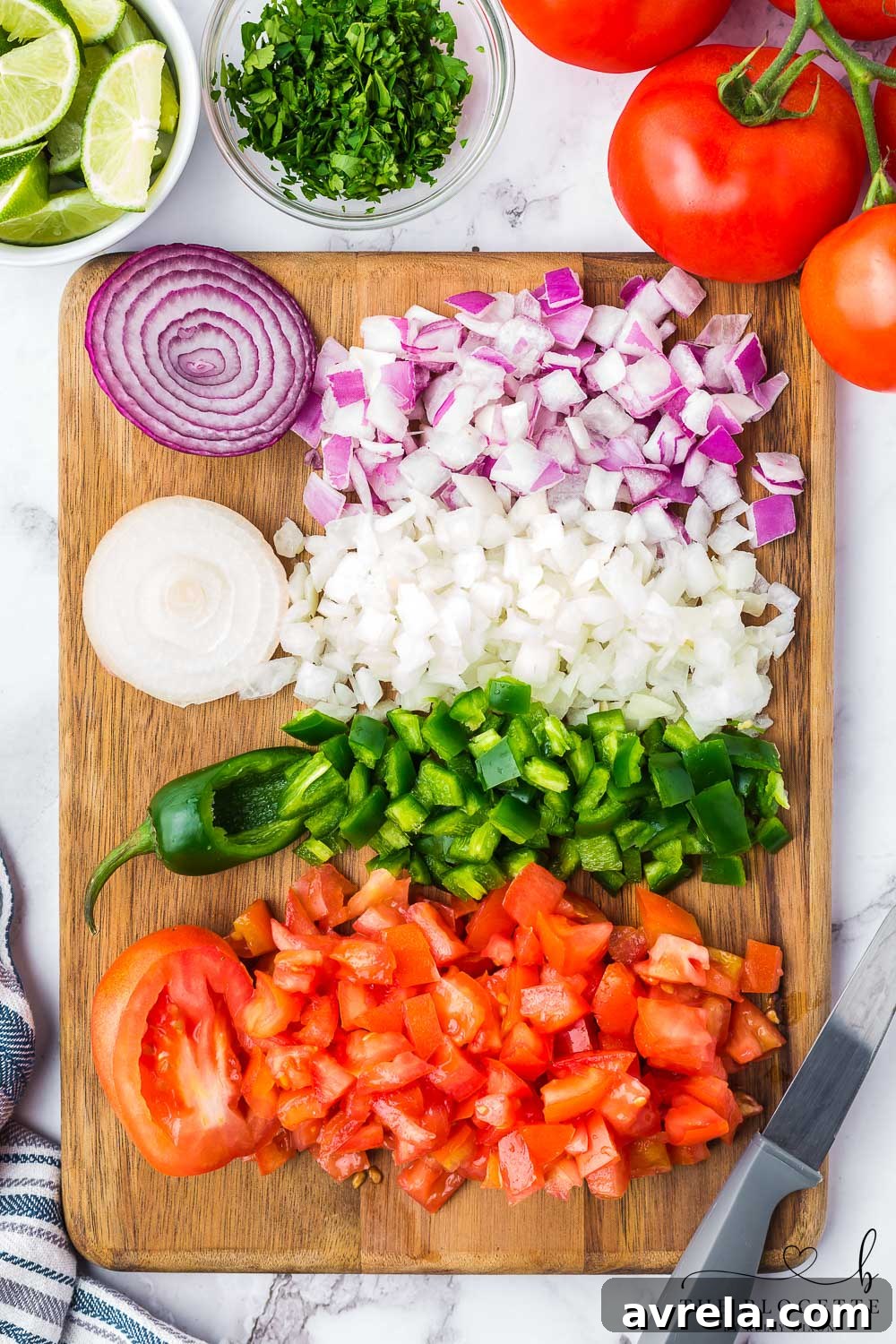 Finely chopped peppers, onions, and tomatoes on a cutting board, prepared for Pico de Gallo.