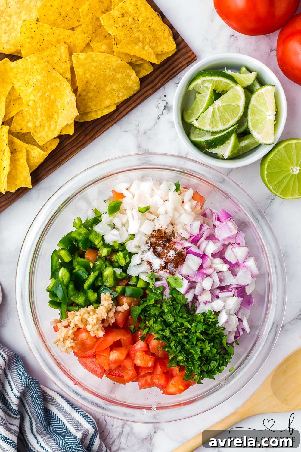 Freshly chopped ingredients for Pico de Gallo in a mixing bowl, ready to be stirred.