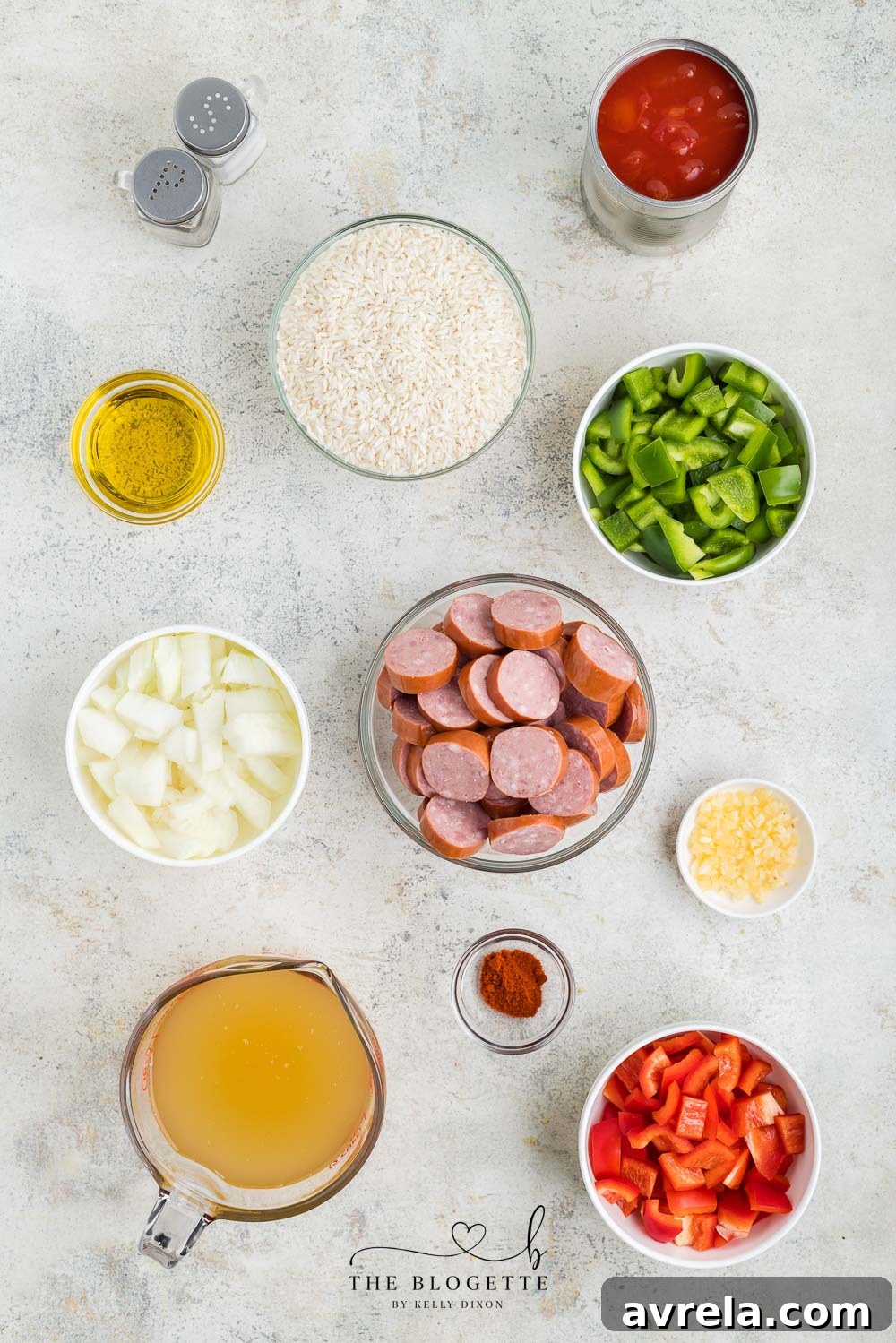 A selection of fresh ingredients for Sausage and Rice Skillet, including bell peppers, onion, garlic, and smoked sausage.