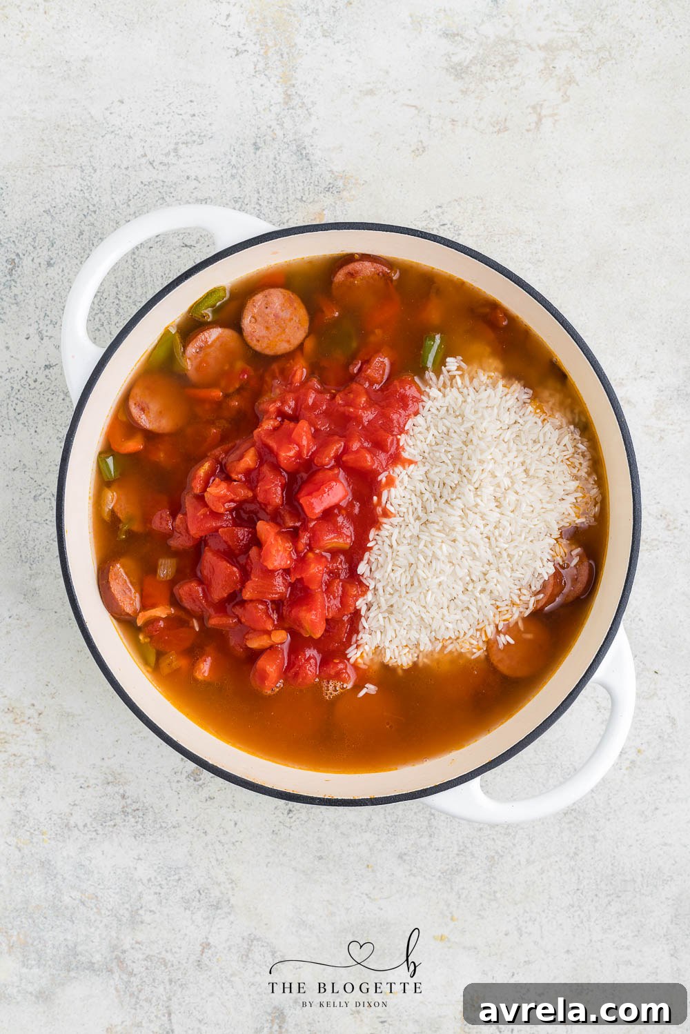 Chicken broth, diced tomatoes, and long-grain rice added to the skillet ingredients.
