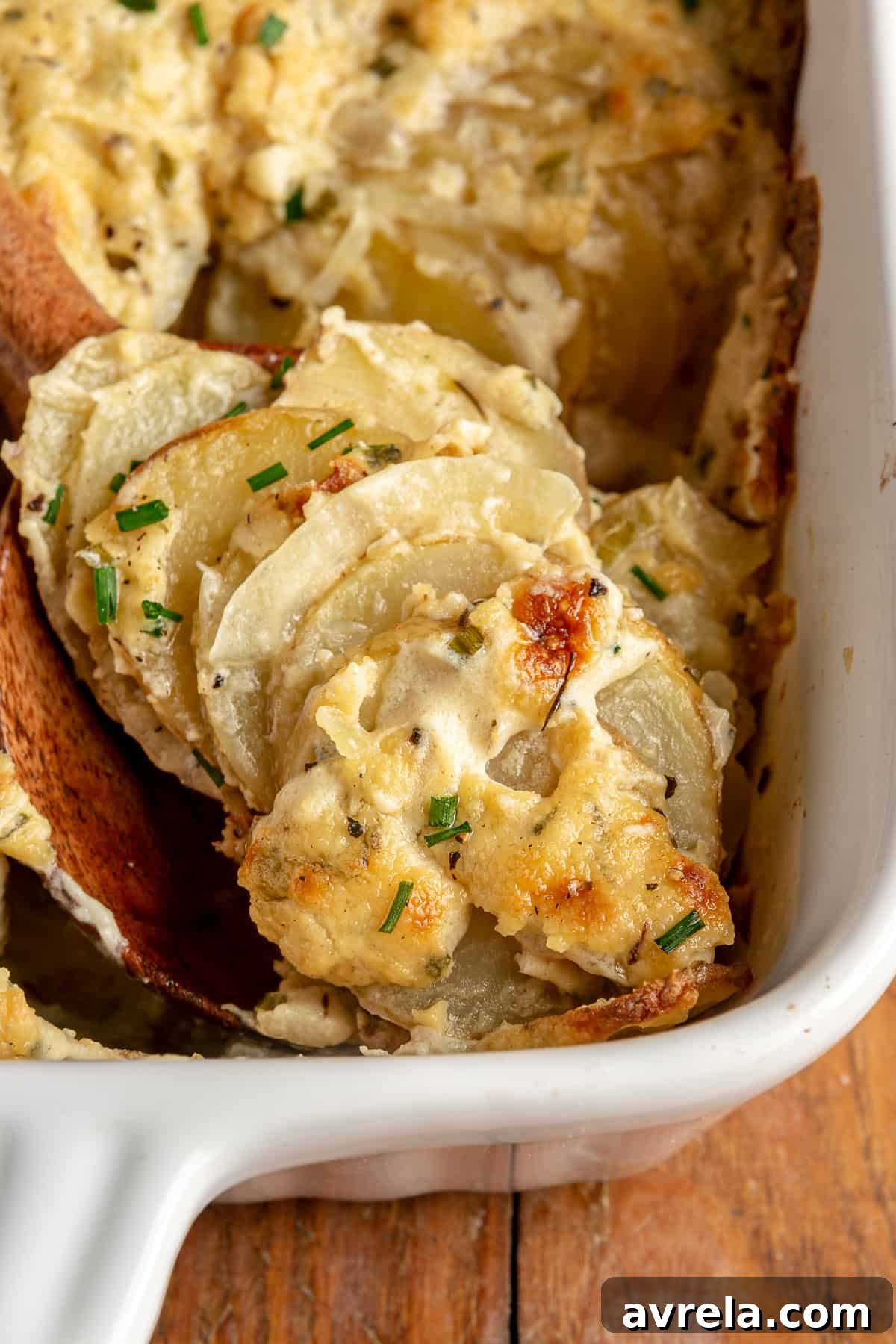 A dish of Dairy-Free Potato Gratin with golden top and fresh chives.