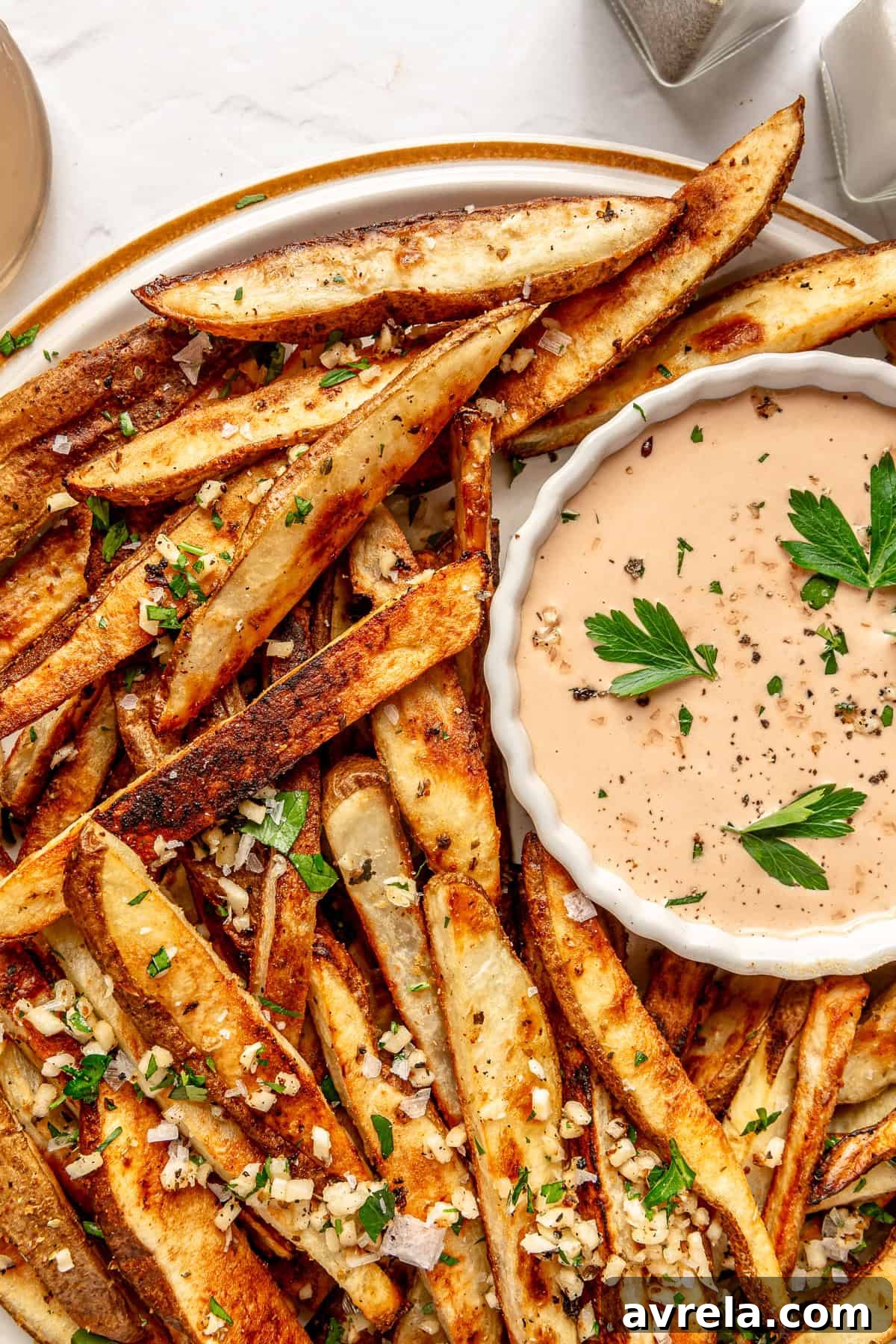 Gameday Garlic Fries served in a bowl with dipping sauce.