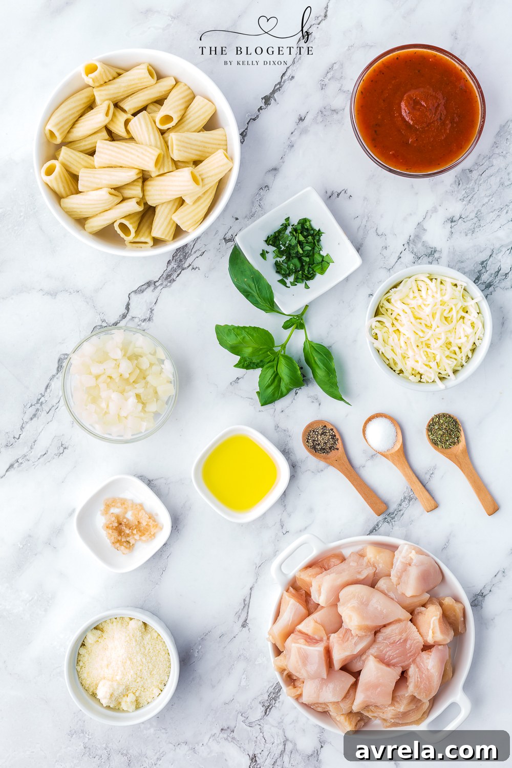 Creamy Chicken Parmesan Pasta 4 Assortment of fresh ingredients for Chicken Parmesan Pasta, including chicken, pasta, marinara, cheese, and herbs.