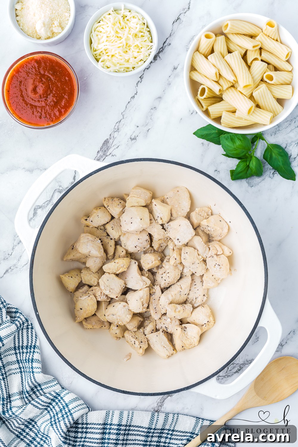 Creamy Chicken Parmesan Pasta 5 Cubed chicken breasts being seared in olive oil in a large Dutch oven.
