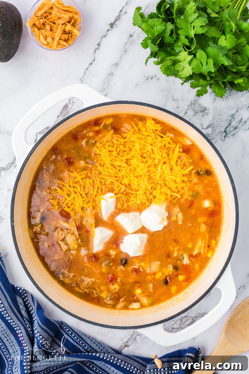 Melted cheese creating a smooth and creamy texture in the chicken enchilada soup, ready to serve.