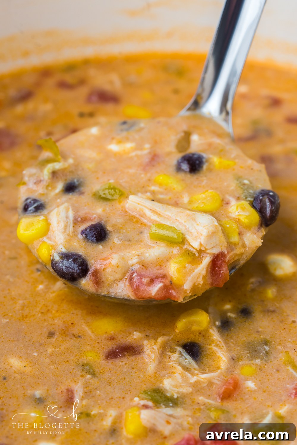 A bowl of homemade Chicken Enchilada Soup garnished with fresh cilantro, avocado, and sour cream, ready to be enjoyed.