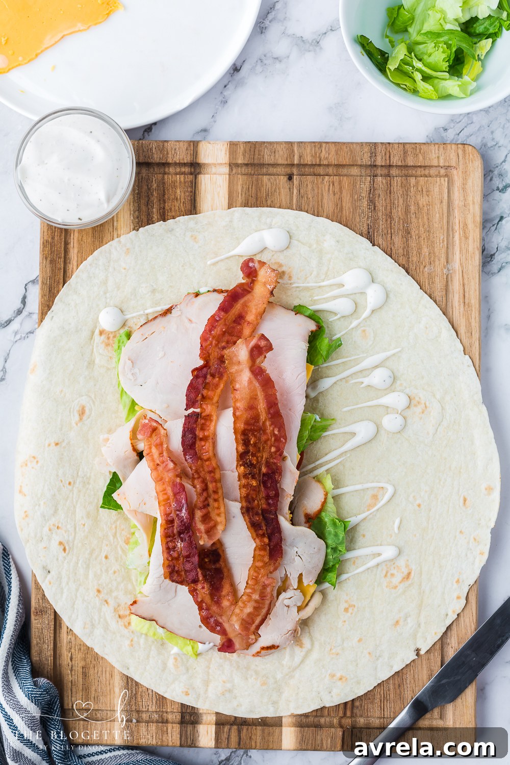 A freshly rolled Turkey Ranch Club Wrap, showing the delicious filling peeking out, ready to be enjoyed as a quick and satisfying meal.