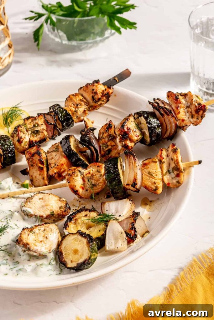 Herby Greek Chicken Skewers with Tzatziki, garnished with fresh dill.