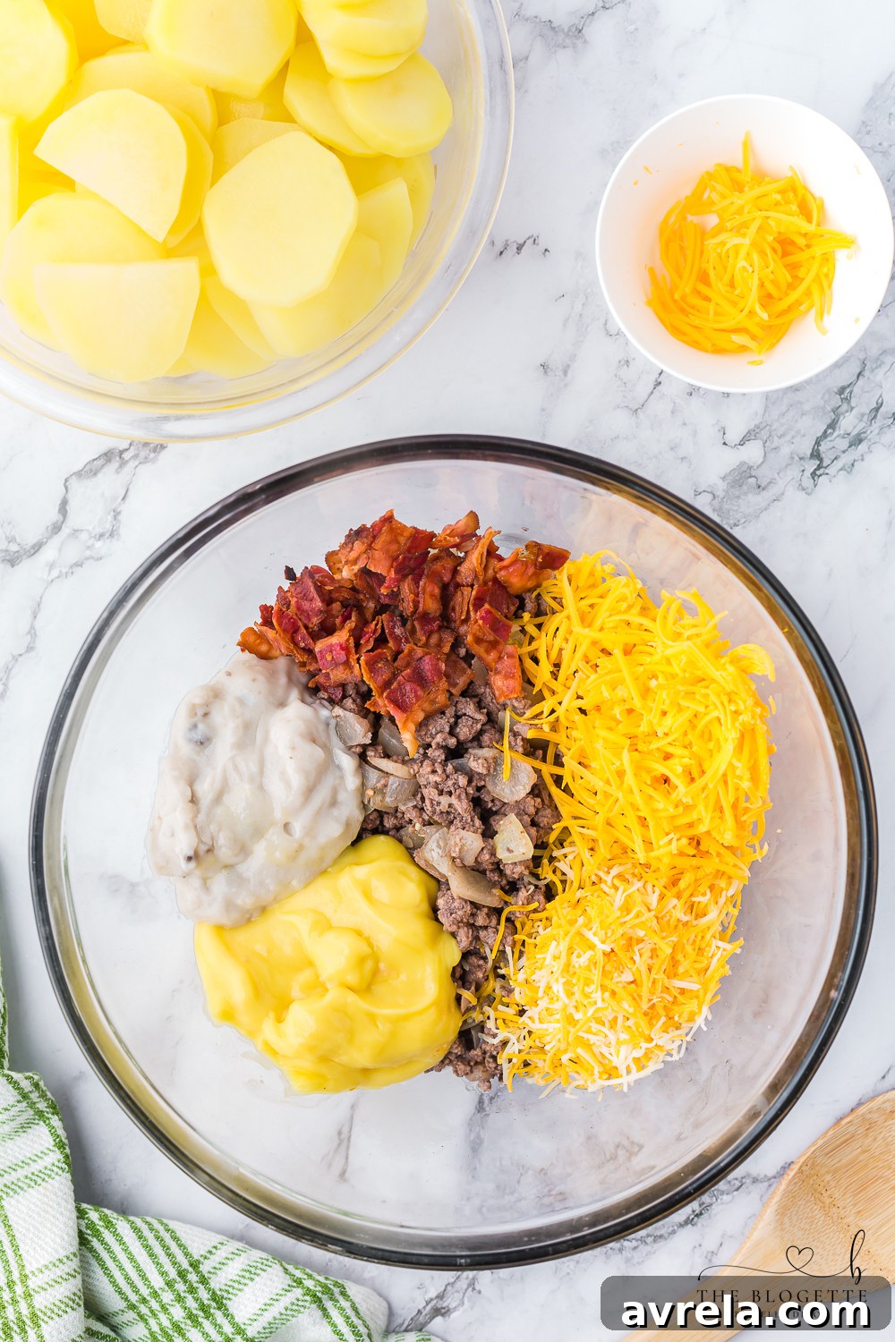 Hearty Beef and Potato Bake 7 Various creamy ingredients, including canned soups, half and half, and Worcestershire sauce, in a large mixing bowl.