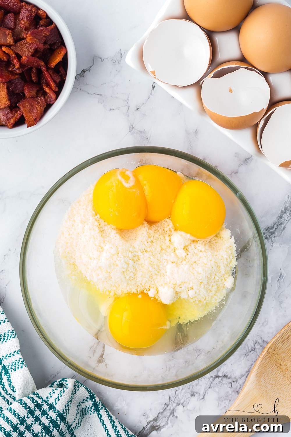 The whisked egg and cheese mixture in a bowl, ready to be tempered with hot pasta water, a critical step to achieve a smooth and creamy Carbonara sauce without scrambling the eggs.