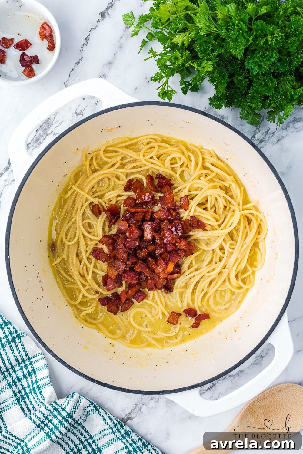 Perfectly cooked spaghetti carbonara with crispy bacon mixed into a creamy sauce, ready to be served. This image captures the delicious texture and appeal of the finished dish.