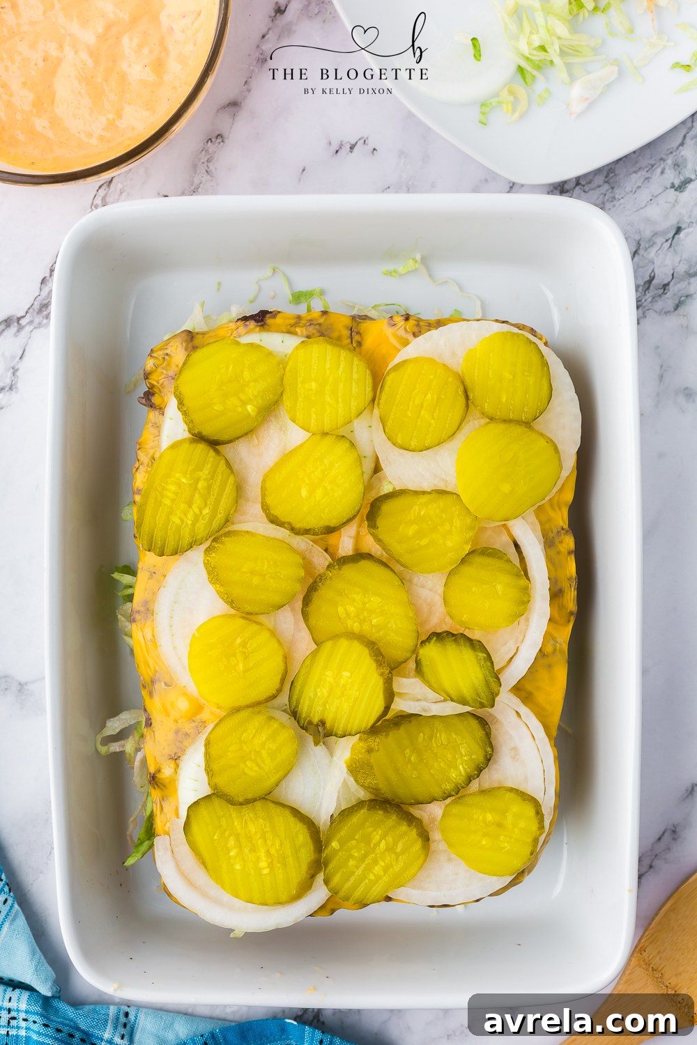 Mini Big Mac Bites 13 Sliced pickles being added to the Big Mac Sliders, followed by a drizzle of the remaining special sauce.