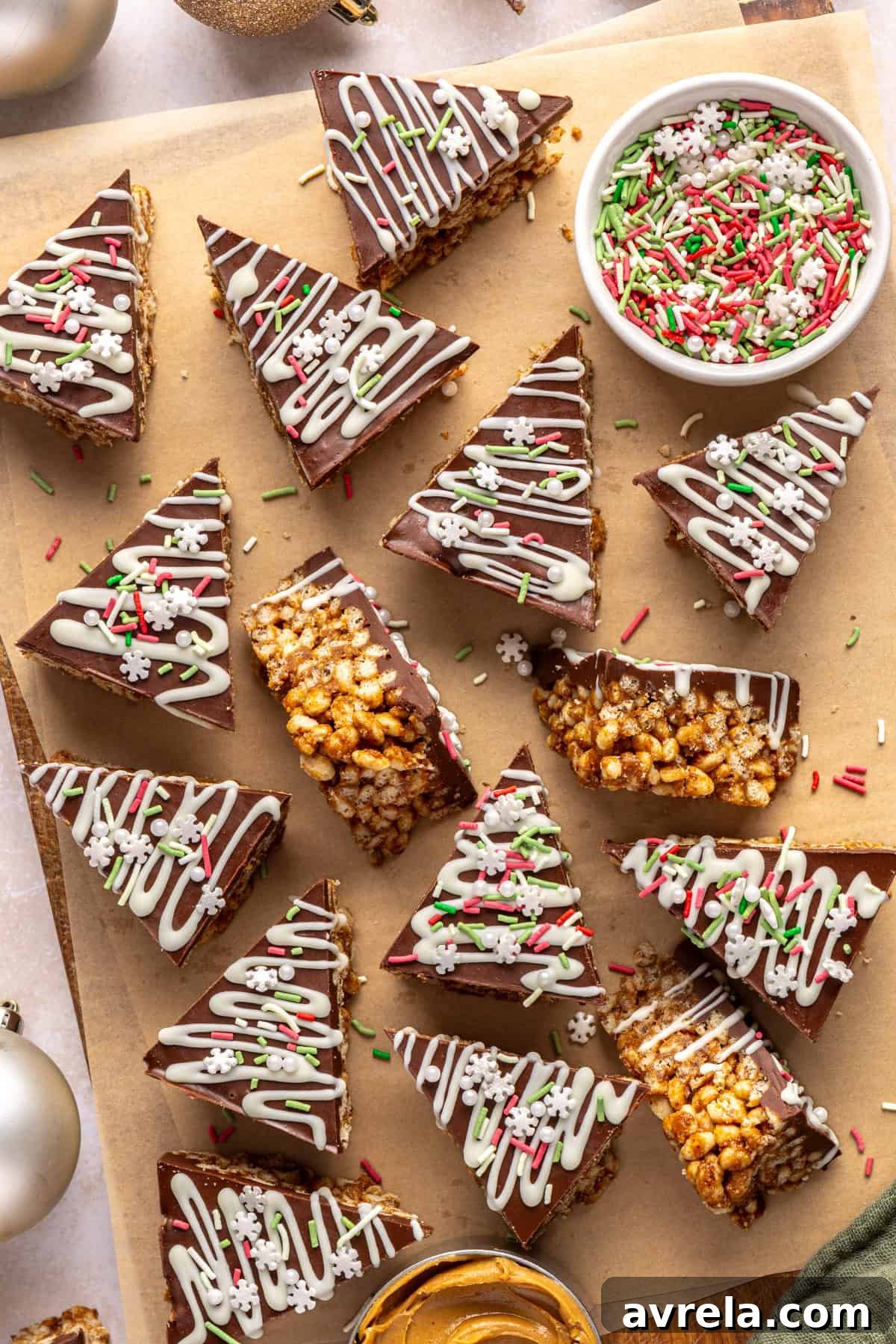 Salted Peanut Butter Fudge Bars 2 Finished salted peanut butter bars on a parchment-lined wooden board with a bowl of sprinkles and peanut butter nearby.