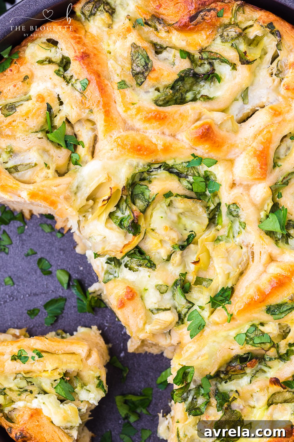 A beautiful serving platter showcasing perfectly baked Cheesy Spinach Artichoke Pinwheels, garnished with fresh parsley and ready for guests to enjoy.