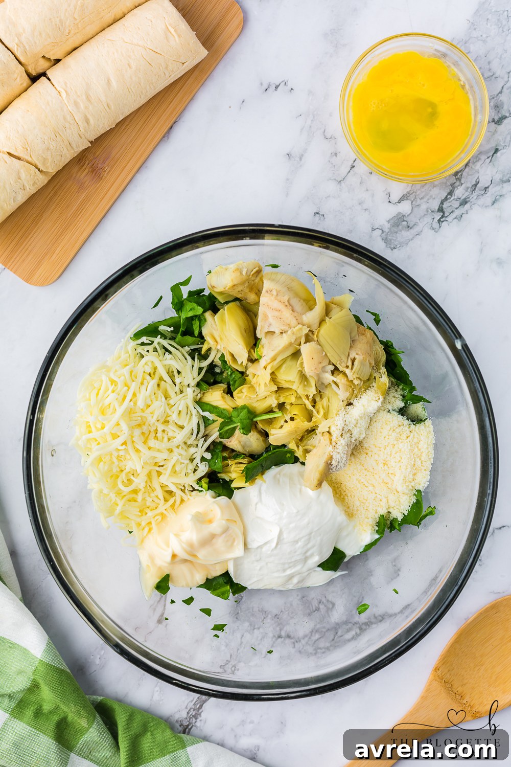 A mixing bowl filled with the creamy, cheesy artichoke and spinach stuffing, perfectly prepared and ready to be spread onto the dough.