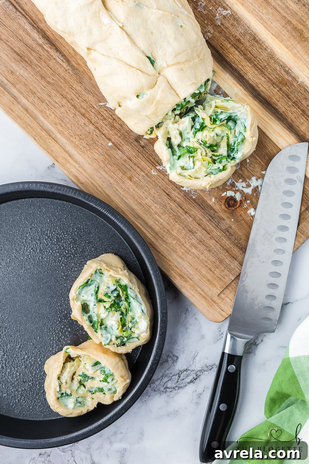 Freshly sliced Cheesy Spinach Artichoke Pinwheels meticulously arranged in a pie plate, brushed with egg wash and perfectly ready for baking.